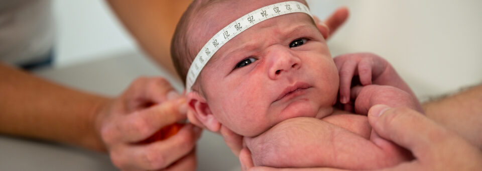 De hoofdomtrek van een baby wordt gemeten door een professional bij het consultatiebureau van het CJG