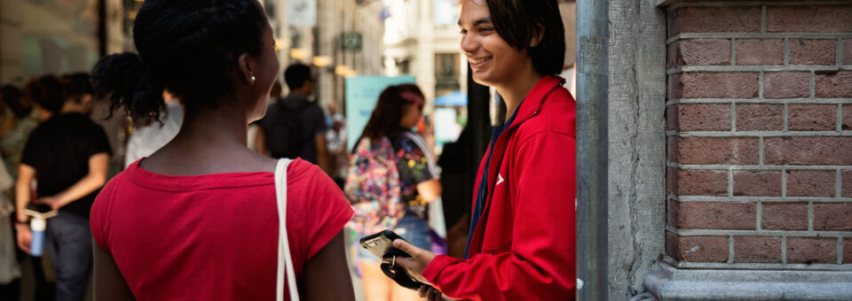 Tieners in de binnenstad van Den Haag kijken elkaar aan en lachen naar elkaar.