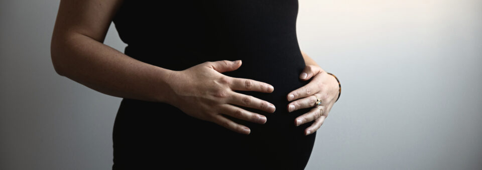 Handen van de zwangere dame op haar buik