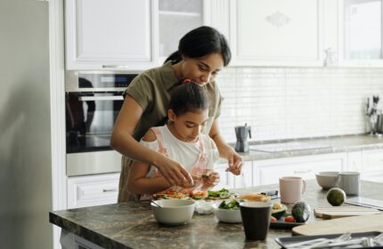 Kind maakt samen met moeder een gezonde lunch klaar in de keuken